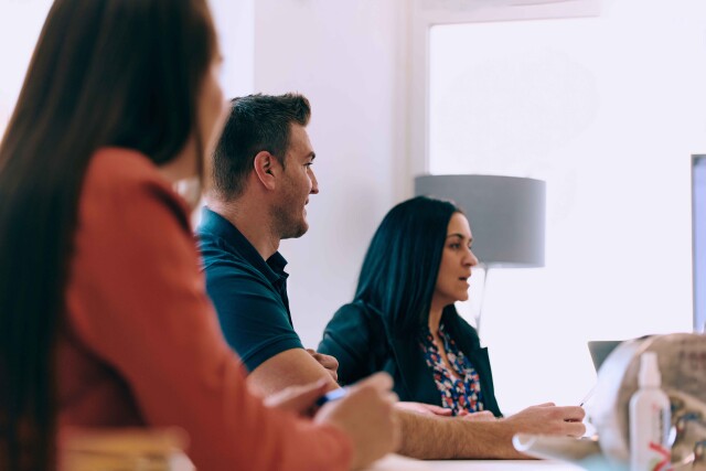 Diverse business team discussing projects in a modern glass