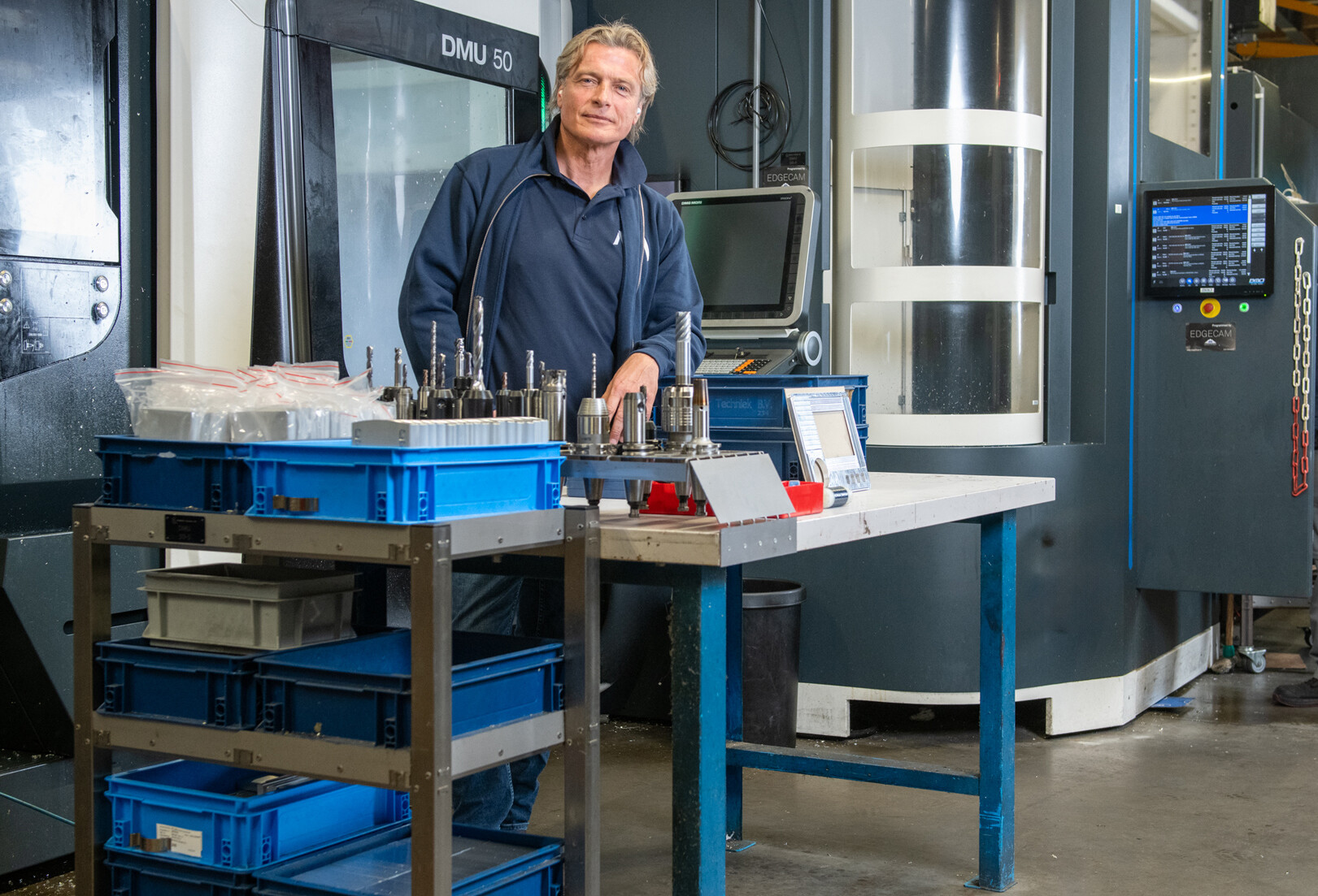 Afbeelding van een persoon in een technische werkplek met machines en materialen